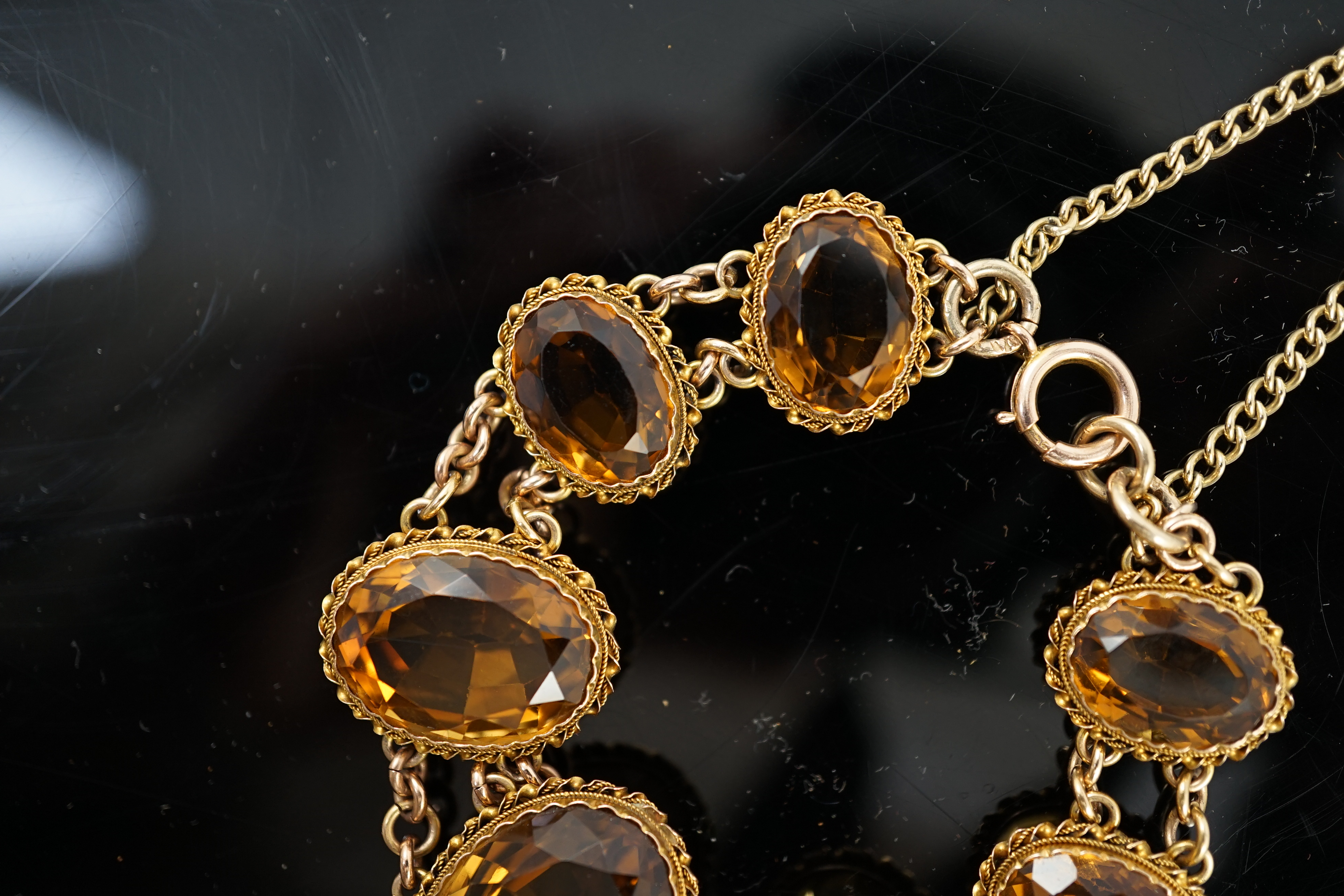 An early 20th century 9ct gold and graduated seven stone oval cut citrine set bracelet